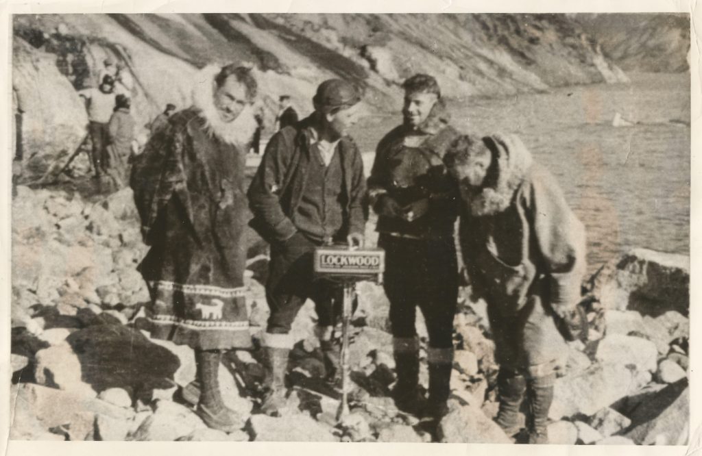 Parker Cramer, Elmer Etes, Duncan Stewart och Bert Hassell efter räddningen. Elmer håller utombordsmotorn från båten de använde för att plocka upp flygaressen med. Ur Midway Village Museums samlingar, Rockford, Illinois, USA.